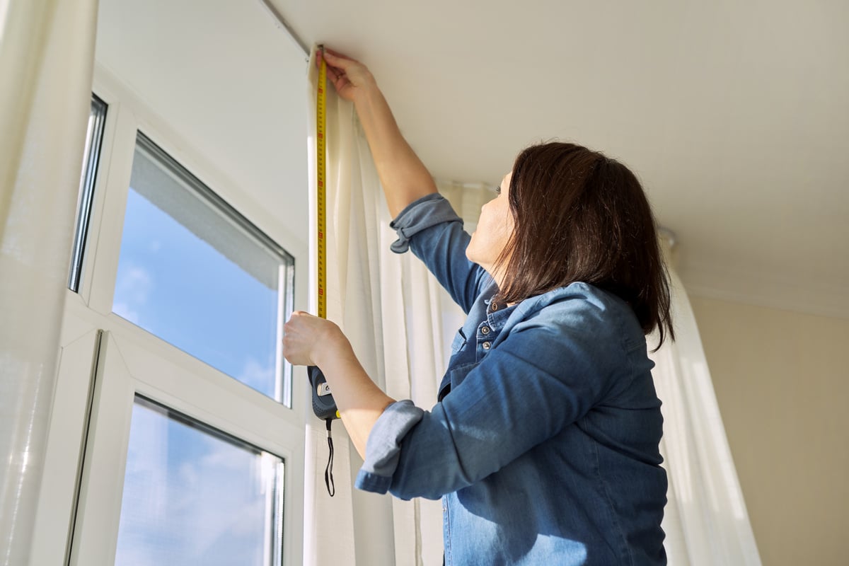 Service for Sewing and Hanging Curtains. Woman with Tape Measure Measuring Window