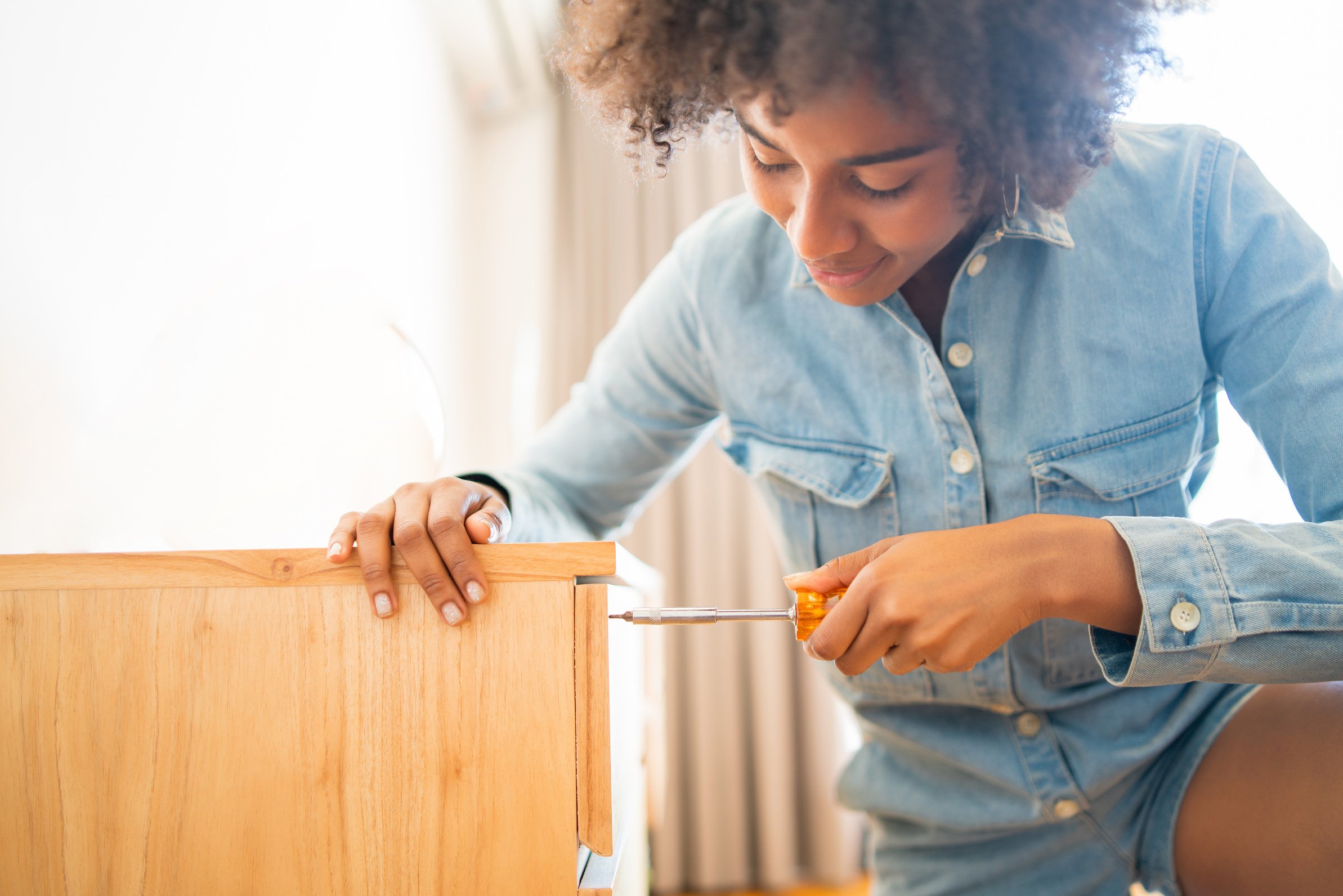 Woman Repairing Cabinet at Home